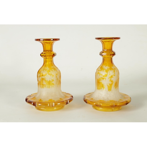 23 - A FINE PAIR OF 19TH CENTURY BOHEMIAN AMBER FLASHED GLASS DECANTERS decorated with Stags amongst wood... 