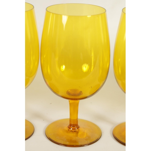 25 - A SET OF SIX URANIUM AMBER GLASS WINE GOBLETS the deep rounded bowls on short stems and flat circula... 