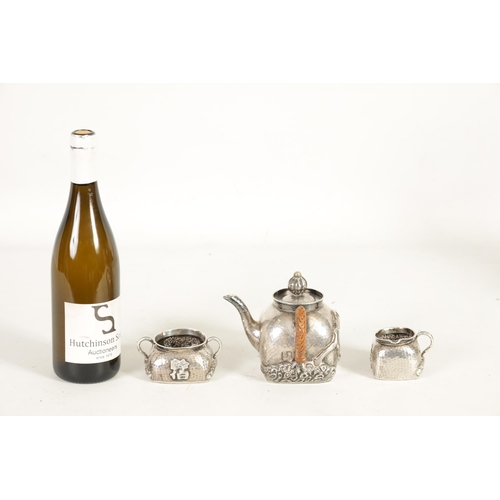 253 - AN EARLY 20TH CENTURY CHINESE SILVER THREE PIECE TEA SET of square form and planished design decorat... 