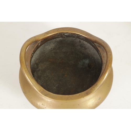 259 - A CHINESE CAST BRONZE CENSER with raised open side handles above a plain rounded body and three peg ... 