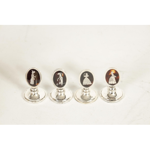 297 - A SET OF FOUR GEORGE V SILVER AND TORTOISESHELL OVAL MENU HOLDERS depicting elegant ladies in fine c... 