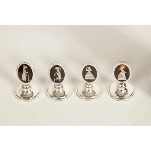 297 - A SET OF FOUR GEORGE V SILVER AND TORTOISESHELL OVAL MENU HOLDERS depicting elegant ladies in fine c... 