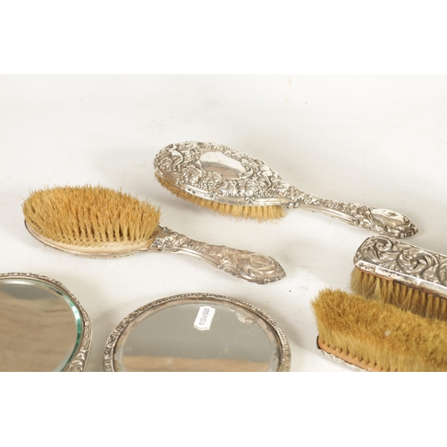 305 - A 19TH CENTURY SILVER DRESSING TABLE SET comprising of four brushes and two mirrors, having leaf and... 