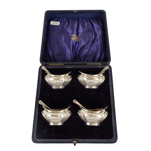 321 - AN EDWARD VII CASED SET OF FOUR SILVER OPEN SALTS AND SPOONS the oval boat-shaped bodies with gilt i... 