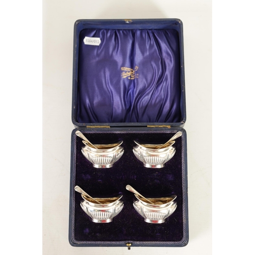 321 - AN EDWARD VII CASED SET OF FOUR SILVER OPEN SALTS AND SPOONS the oval boat-shaped bodies with gilt i... 