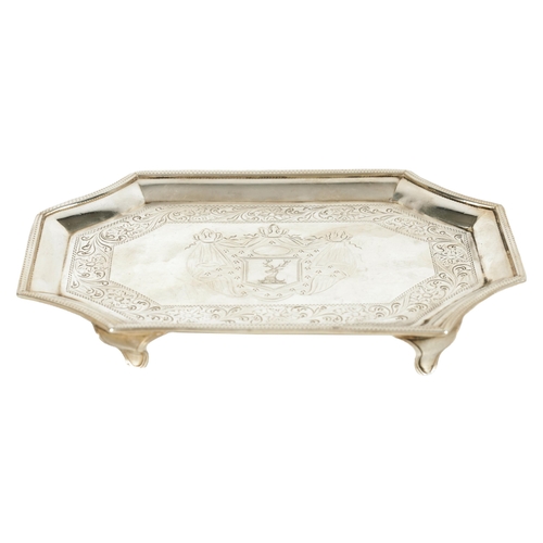 326 - A GEORGE III SILVER RECTANGULAR CARD TRAY with concave corners and engraved border enclosing a coat ... 