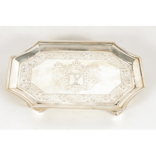 326 - A GEORGE III SILVER RECTANGULAR CARD TRAY with concave corners and engraved border enclosing a coat ... 