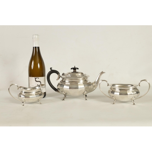 327 - A GEORGE V THREE-PIECE SILVER TEA SERVICE of oblate panelled form raised on splay feet; comprising t... 