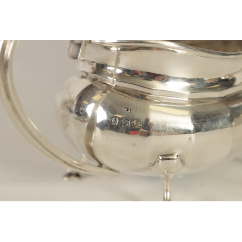 327 - A GEORGE V THREE-PIECE SILVER TEA SERVICE of oblate panelled form raised on splay feet; comprising t... 