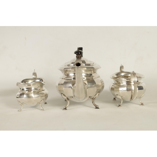 327 - A GEORGE V THREE-PIECE SILVER TEA SERVICE of oblate panelled form raised on splay feet; comprising t... 