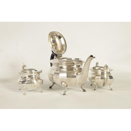 327 - A GEORGE V THREE-PIECE SILVER TEA SERVICE of oblate panelled form raised on splay feet; comprising t... 