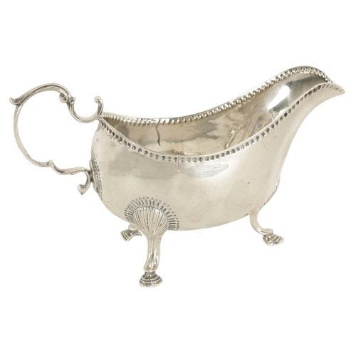 345 - A GEORGE III IRISH SILVER SAUCE BOAT with leaf-capped scroll handle, shell work knees and hoof feet ... 