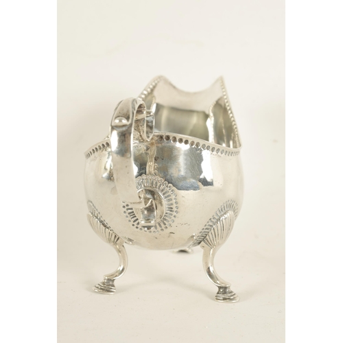 345 - A GEORGE III IRISH SILVER SAUCE BOAT with leaf-capped scroll handle, shell work knees and hoof feet ... 