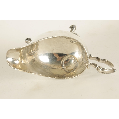 345 - A GEORGE III IRISH SILVER SAUCE BOAT with leaf-capped scroll handle, shell work knees and hoof feet ... 