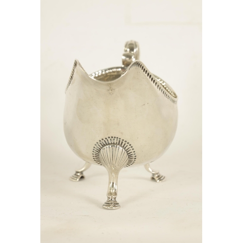 345 - A GEORGE III IRISH SILVER SAUCE BOAT with leaf-capped scroll handle, shell work knees and hoof feet ... 