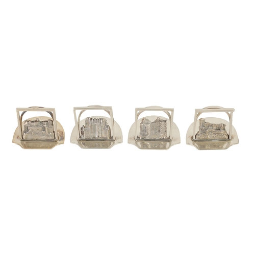 346 - A SET OF FOUR GEORGE V SILVER SCOTTISH CASTLE SCENE MENU HOLDERS of openwork design on solid shaped ... 