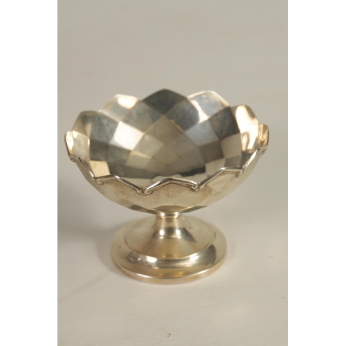 351 - A GEORGE V PEDESTAL SILVER SWEETMEAT BASKET of panelled form with pierced gadroon-edged rim and cut-... 