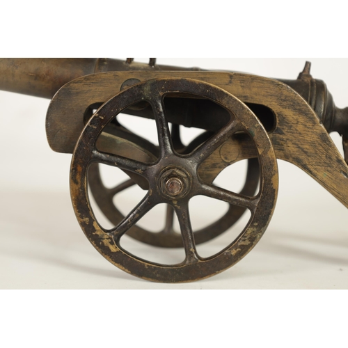 365 - A 19TH CENTURY BRONZE STARTING CANNON mounted on a gilt brass carriage with six spoke wheels and iro... 