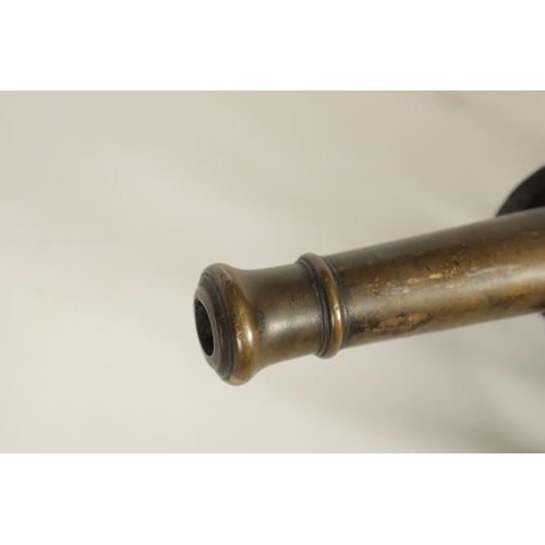 365 - A 19TH CENTURY BRONZE STARTING CANNON mounted on a gilt brass carriage with six spoke wheels and iro... 