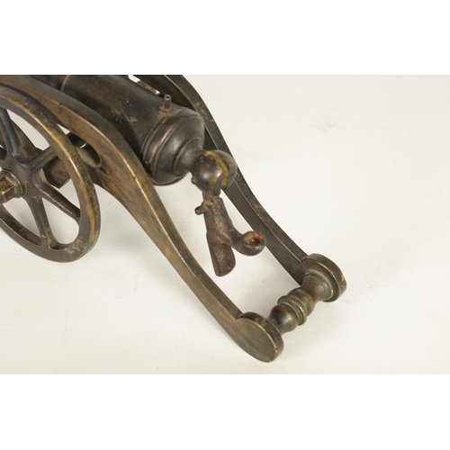 365 - A 19TH CENTURY BRONZE STARTING CANNON mounted on a gilt brass carriage with six spoke wheels and iro... 