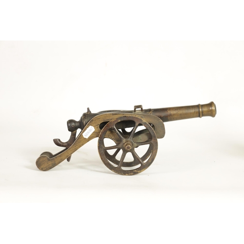 365 - A 19TH CENTURY BRONZE STARTING CANNON mounted on a gilt brass carriage with six spoke wheels and iro... 