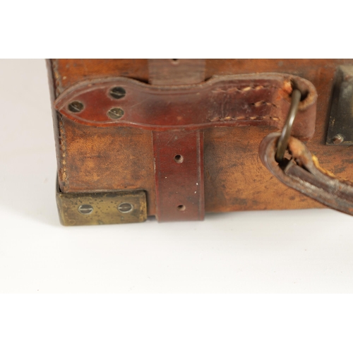 379 - A 19TH CENTURY LEATHER BOUND CARTRIDGE CASE with brass corners and leather straps revealing a lined ... 