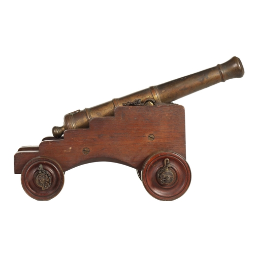 381 - AN 18TH/19TH CENTURY BRONZE STARTING CANNON with proof marks; mounted on an oak cutout carriage with... 