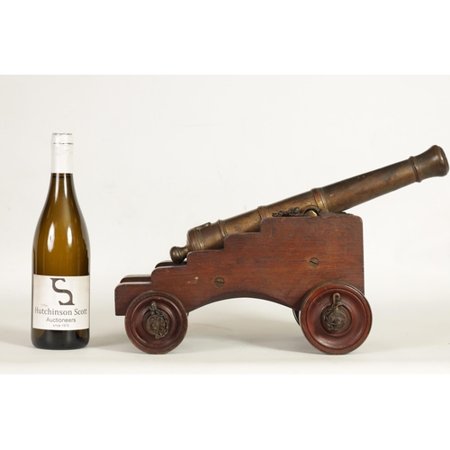 381 - AN 18TH/19TH CENTURY BRONZE STARTING CANNON with proof marks; mounted on an oak cutout carriage with... 