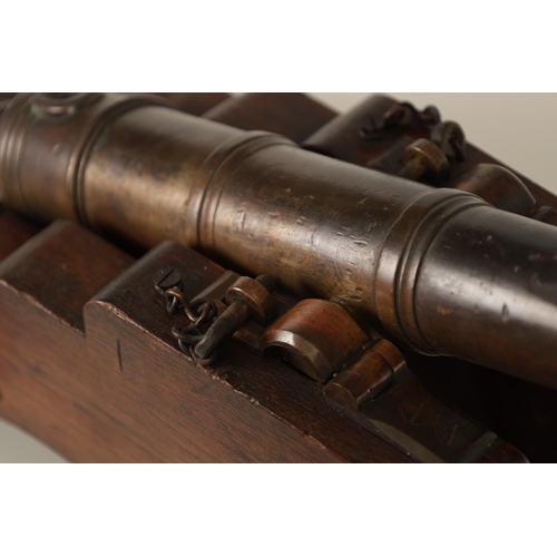 381 - AN 18TH/19TH CENTURY BRONZE STARTING CANNON with proof marks; mounted on an oak cutout carriage with... 