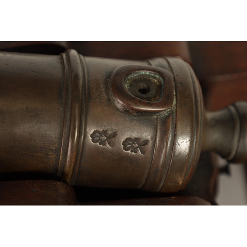 381 - AN 18TH/19TH CENTURY BRONZE STARTING CANNON with proof marks; mounted on an oak cutout carriage with... 