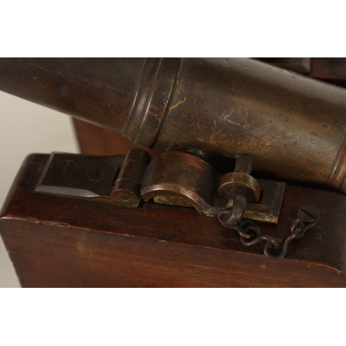 381 - AN 18TH/19TH CENTURY BRONZE STARTING CANNON with proof marks; mounted on an oak cutout carriage with... 