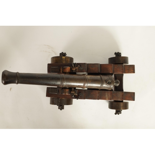 381 - AN 18TH/19TH CENTURY BRONZE STARTING CANNON with proof marks; mounted on an oak cutout carriage with... 