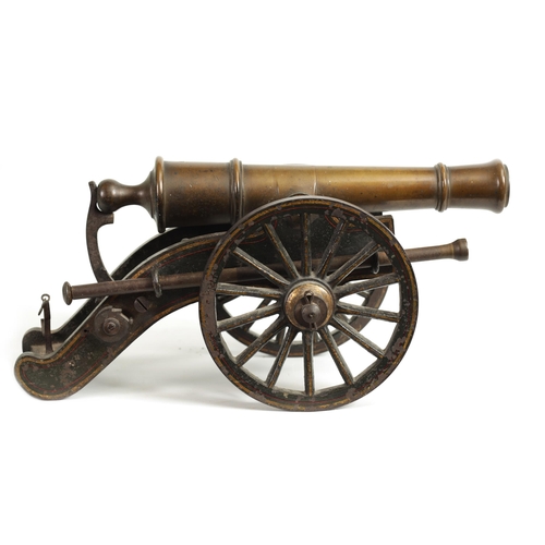 389 - A 19TH CENTURY BRONZE AND CAST IRON STARTING CANNON with painted and gilt high-lighted carriage fitt... 