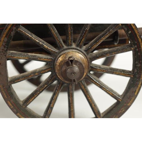 389 - A 19TH CENTURY BRONZE AND CAST IRON STARTING CANNON with painted and gilt high-lighted carriage fitt... 