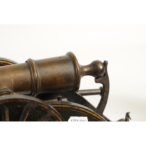 389 - A 19TH CENTURY BRONZE AND CAST IRON STARTING CANNON with painted and gilt high-lighted carriage fitt... 