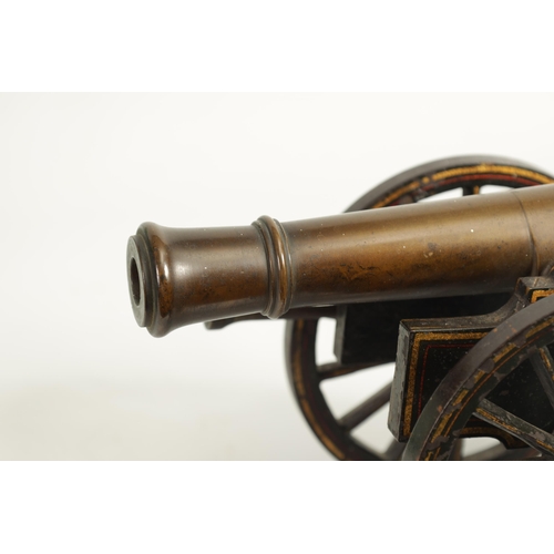 389 - A 19TH CENTURY BRONZE AND CAST IRON STARTING CANNON with painted and gilt high-lighted carriage fitt... 