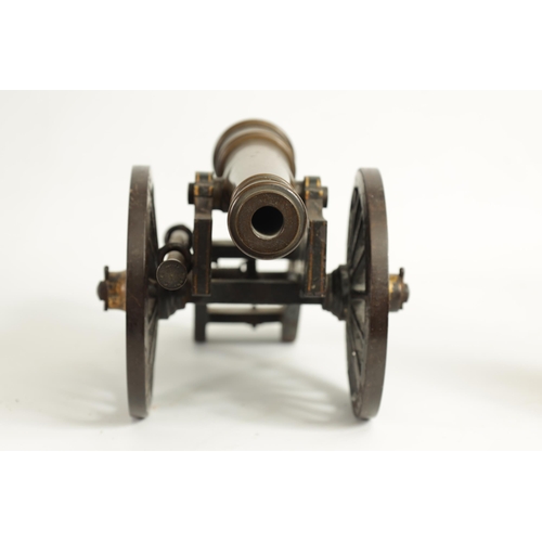 389 - A 19TH CENTURY BRONZE AND CAST IRON STARTING CANNON with painted and gilt high-lighted carriage fitt... 