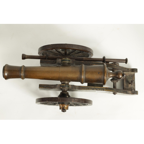 389 - A 19TH CENTURY BRONZE AND CAST IRON STARTING CANNON with painted and gilt high-lighted carriage fitt... 