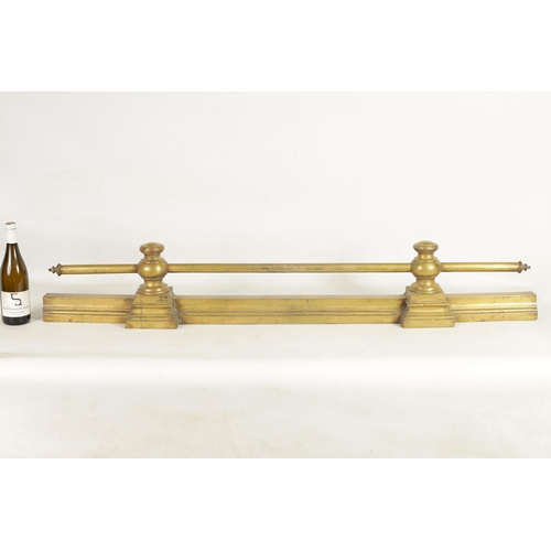 441 - A 19TH CENTURY BRASS FENDER with baluster uprights and rail top, raised on a moulded plinth base (14... 