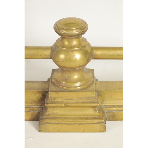 441 - A 19TH CENTURY BRASS FENDER with baluster uprights and rail top, raised on a moulded plinth base (14... 