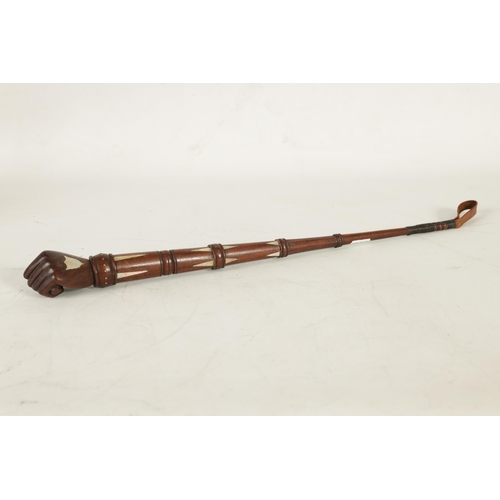 451 - A 19TH CENTURY MAHOGANY AND MOTHER OF PEARL INALID RIDING CROP with fist shaped handle and tapering ... 