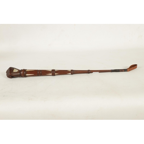 451 - A 19TH CENTURY MAHOGANY AND MOTHER OF PEARL INALID RIDING CROP with fist shaped handle and tapering ... 