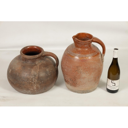 46 - TWO EARLY CONTINENTAL TERRACOTTA POTTERY JUGS one of squat bulbous shape with side handle the other ... 