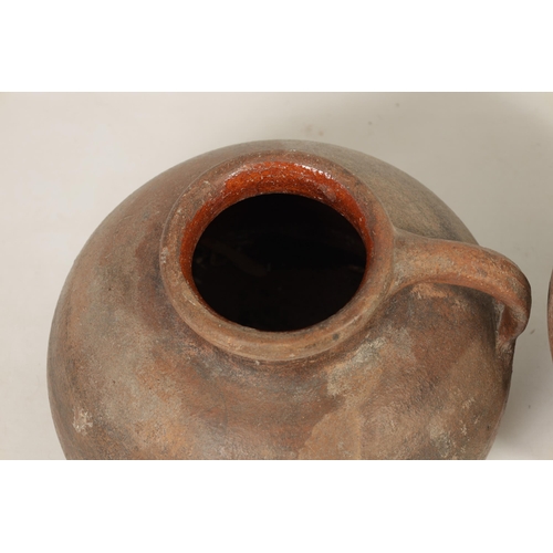 46 - TWO EARLY CONTINENTAL TERRACOTTA POTTERY JUGS one of squat bulbous shape with side handle the other ... 