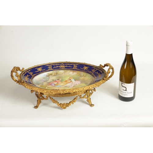 55 - A LATE 19TH CENTURY SERVES STYLE OVAL ORMOLU MOUNTED CENTREPIECE with a painted classical figure sce... 