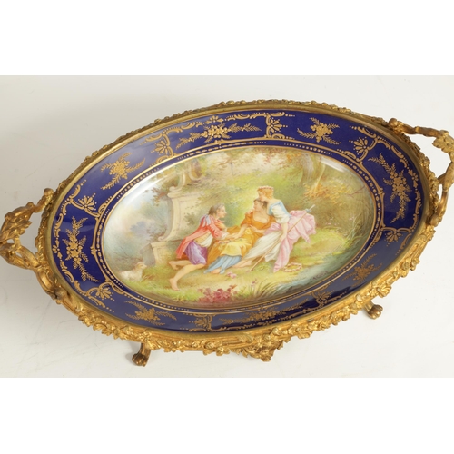 55 - A LATE 19TH CENTURY SERVES STYLE OVAL ORMOLU MOUNTED CENTREPIECE with a painted classical figure sce... 