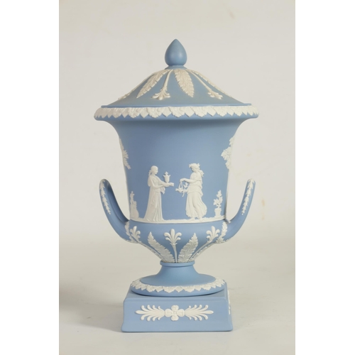 78 - A WEDGWOOD JASPERWARE CAMPANA SHAPED VASE AND COVER decorated with trees, leafwork borders and class... 