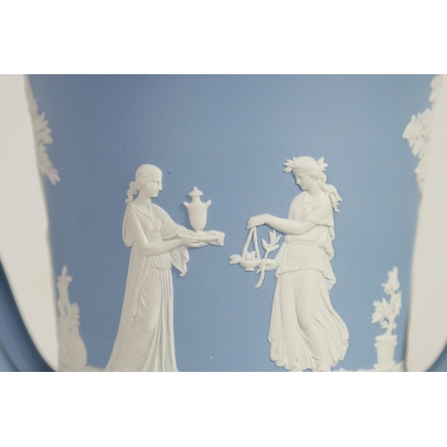 78 - A WEDGWOOD JASPERWARE CAMPANA SHAPED VASE AND COVER decorated with trees, leafwork borders and class... 