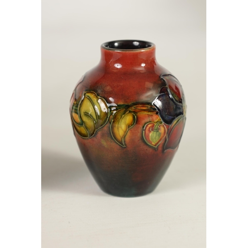 86 - TWO MOORCROFT FLAMBÉ WARE CABINET VASES the 1930's small shouldered tapering Vase tube lined and dec... 