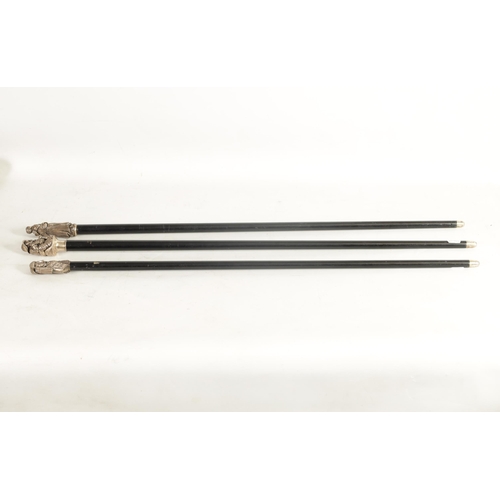 466 - THREE 20TH CENTURY SILVER METAL MOUNTED EBONISED WALKING CANES with cast figural handles. (92cm over... 